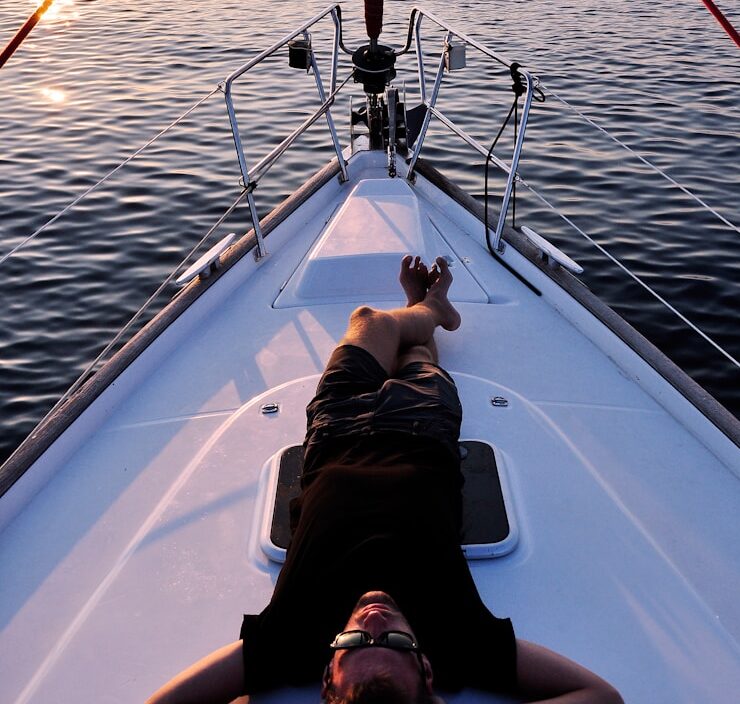 man lying on white boat
